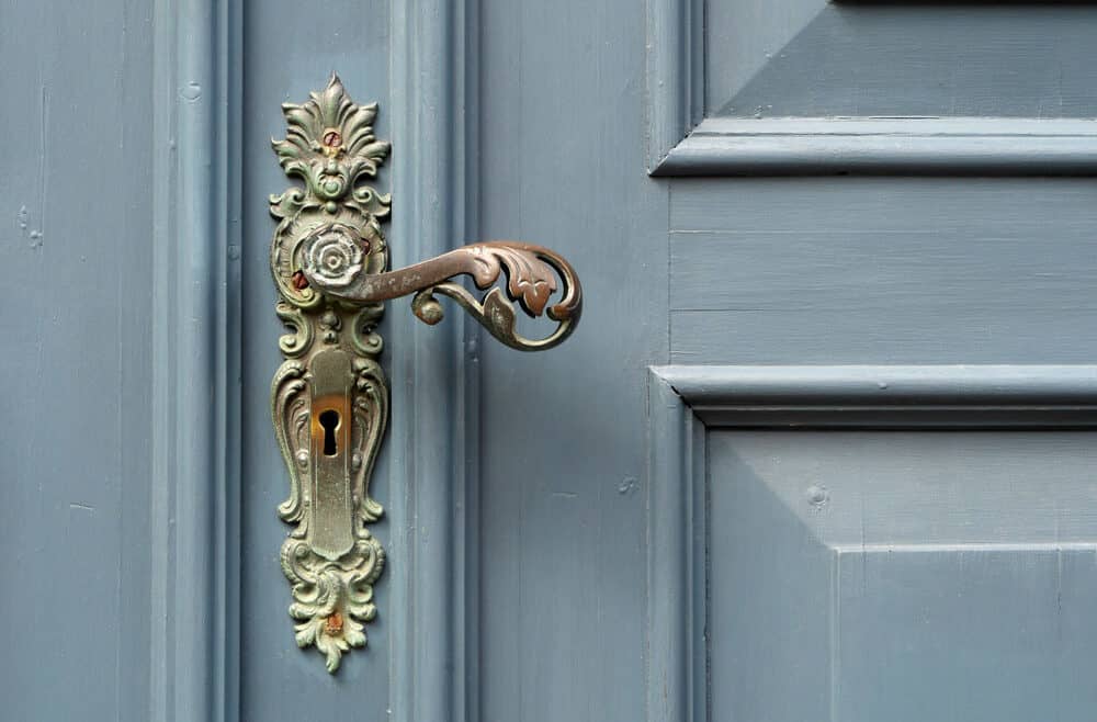 Brass door handle on blue door